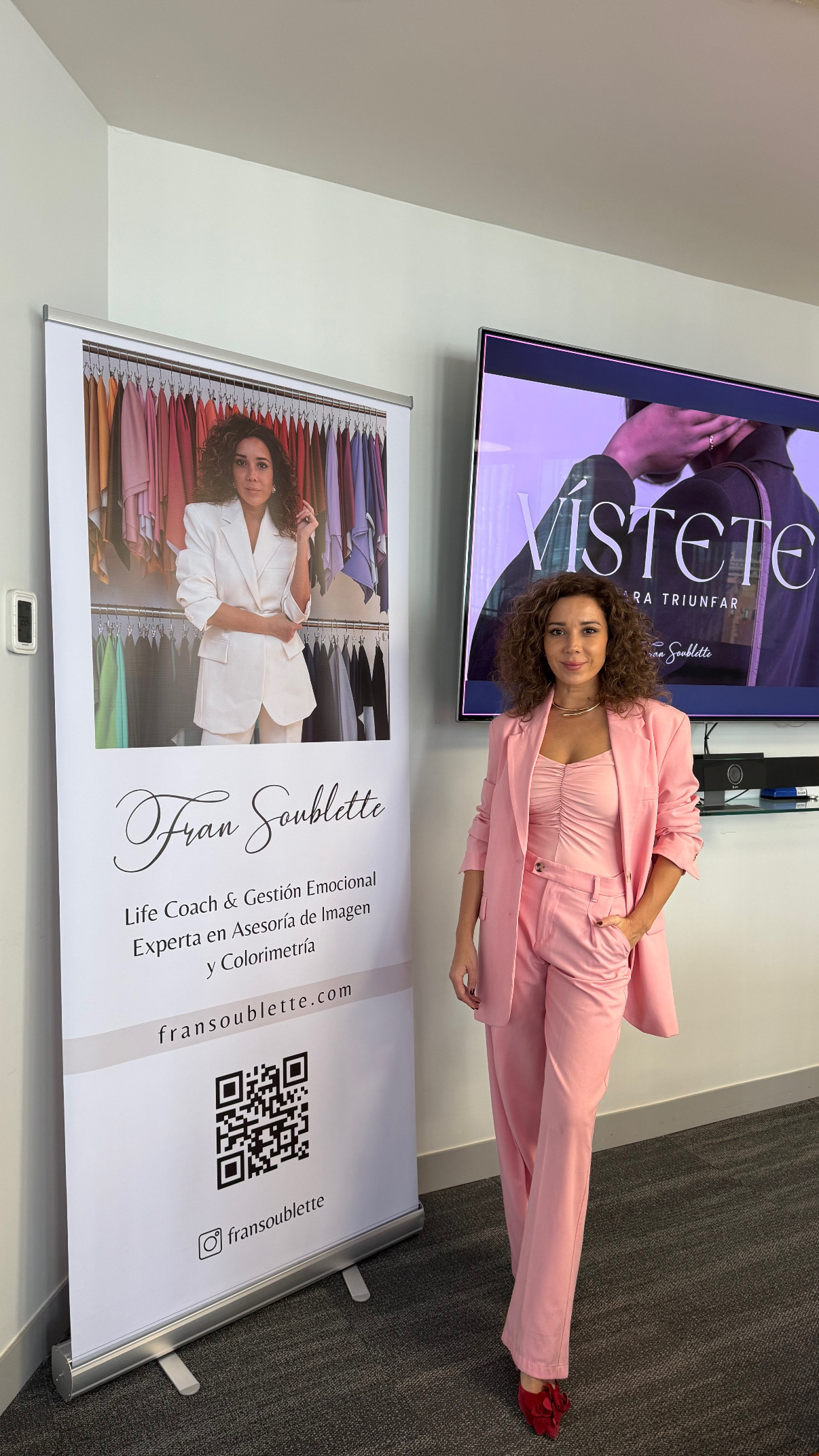 Fran junto a un pendón de su marca en un taller para empresas